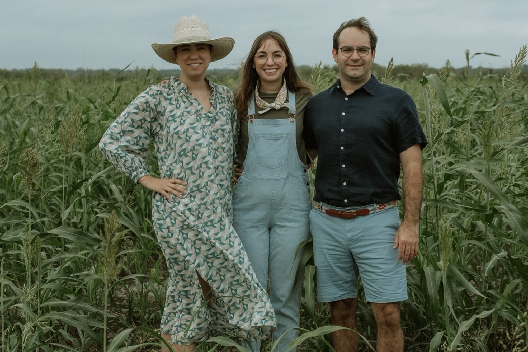 The three sibling owners of Blue Hills — Stephanie, Caroline and Corey — standing together in a green Texas field